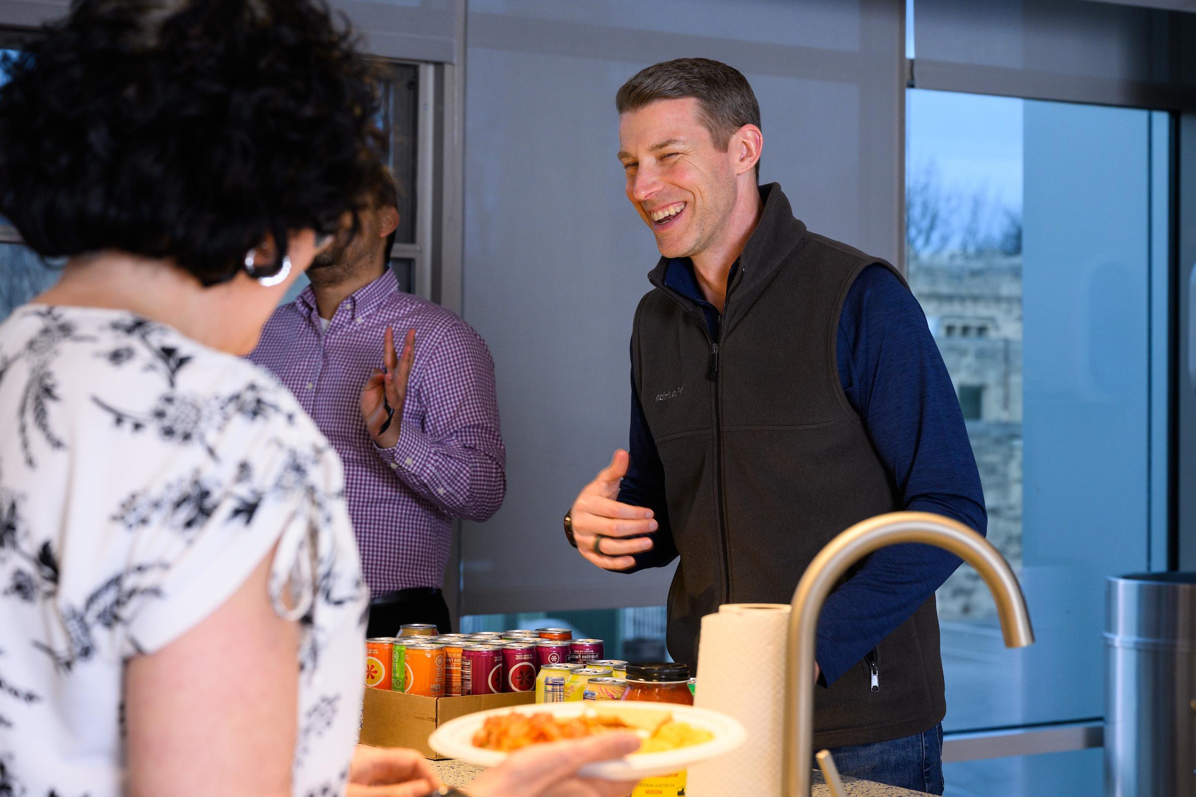 A faculty-in-residence talks to others in a kitchen